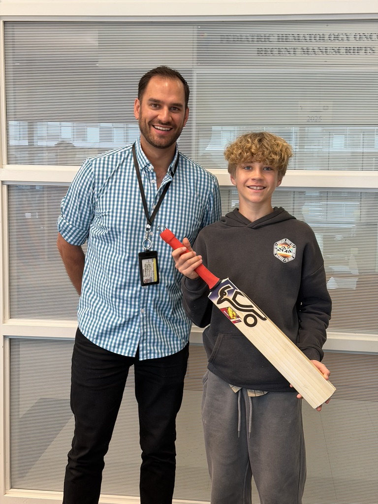 Matthew presenting Beaudin with an authentic cricket bat, freshly back from Australia
